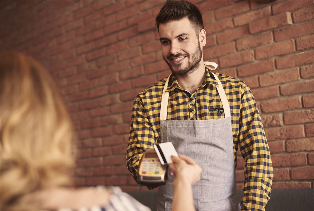 Bankomatkasse in der Gastronomie: Kellner kassiert mit Kartenterminal